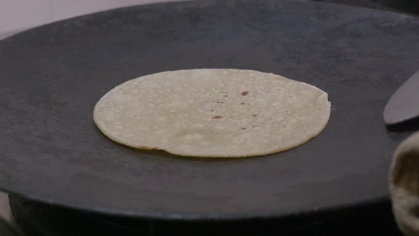 Person failed to make phulka on gas stove flame at home. internal shot, stable shot, 4k.