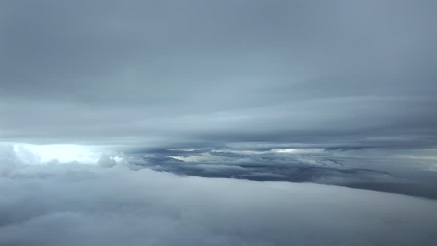 An immersive pilot’s perspective flying between layers of snow winter clouds in a cold atmosphere, captured from a jet caockpit.