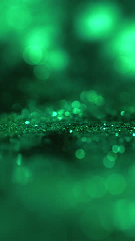 Vertical abstract green bokeh background. Soft blurred glowing lights with glitter texture and shallow depth of field. Modern dreamy backdrop for mobile stories, wellness, tech, cinematic titles, copy space.