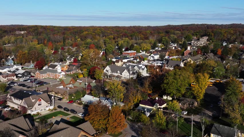 Broad aerial of Nashville Brown County Indiana USA residential area set within expansive autumn forest landscape, wide establishing