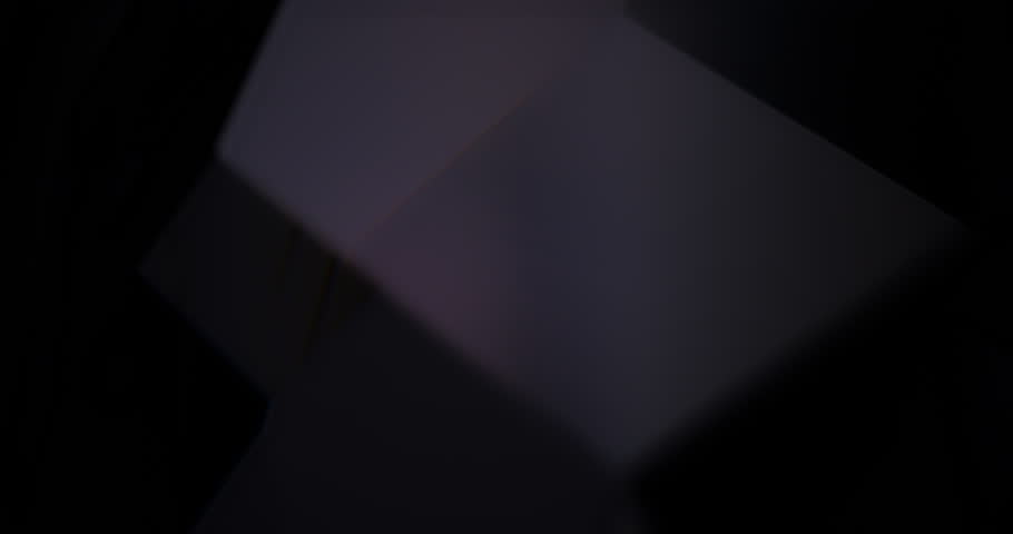 Dark Geometric Shapes Subtle Rotation Loop. Minimalist black abstract forms with faint highlights slowly rotating in elegant, low-key motion against deep void background.