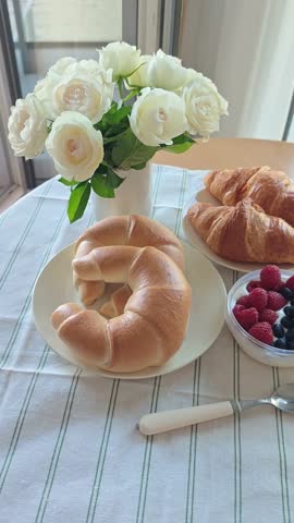 French breakfast served on a table with croissants coffee and fresh bread creating a cozy morning atmosphere in a vertical video format. The concept represents French lifestyle, slow morning routine