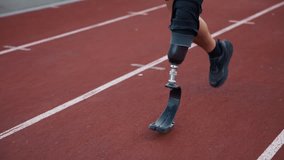 Male athlete running on an athletic track wearing a specific orthopedic prosthesis, prosthetic leg with a blade, close up shot. Disability and sport concept. - Powered by Shutterstock - Get 15% off with code: PIKWIZARD15