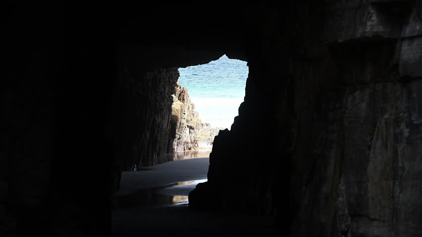 looking through the natural rock formation known as remarkable cave along the rugged rocky coastline of Tasmania, close to Port Arthur, a popular travel destination in Australia.