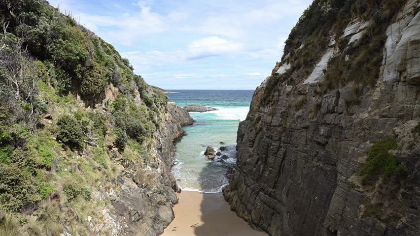 looking through the natural rock formation known as remarkable cave along the rugged rocky coastline of Tasmania, close to Port Arthur, a popular travel destination in Australia.