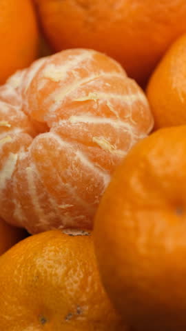 Whole Orange tangerines and peeled tangerine in plate, rotation