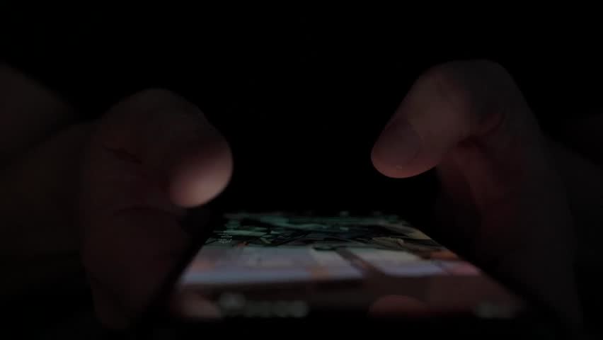 Man Scrolling Social Media. Finger Tapping Smartphone Screen at Night