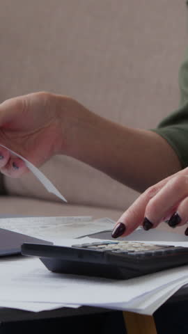 Close up female old hands typing calculator counting money reading check receipt money managing retired unrecognizable granny unknown senior woman checking personal family budget finance with laptop