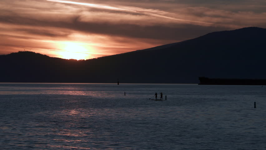 English Bay Paddle Boarding Vancouver 4K UHD.Sunset paddle boarders on English Bay. Vancouver, British Columbia, Canada. 4K, UHD.

