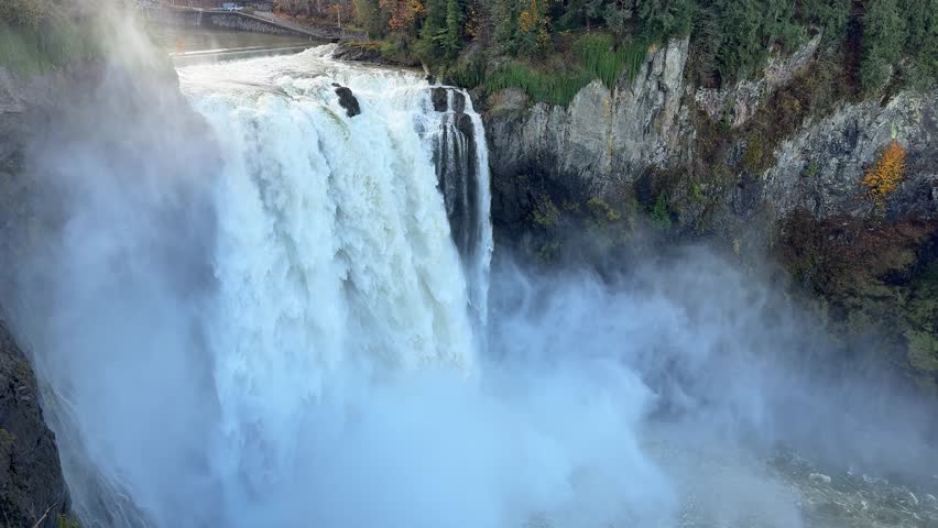 Snoqualmie Falls flowing in mist with rugged rock walls