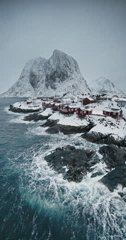 Norwegian sea shore and fishing village in Reine, Lofoten islands, Norway vertical aerial cinematic video