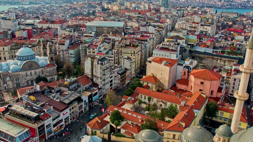 Daytime aerial view of Istanbul’s dense urban texture. Historic buildings, narrow streets, and modern city life blend together, with the distant sea and coastline adding depth to the metropolitan scene.