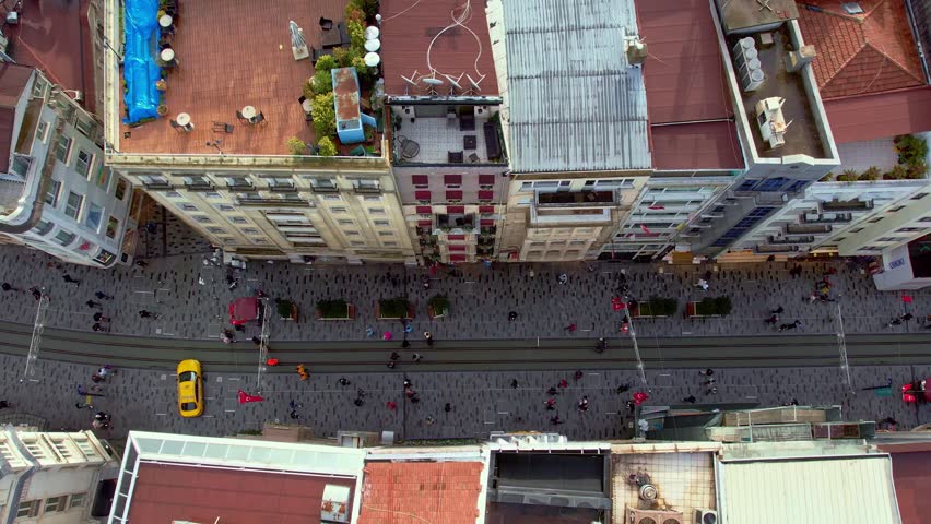 Daytime aerial view of Istiklal Street in Istanbul. Tram line, crowded pedestrian flow and historic buildings reflect the city’s cultural identity, tourism appeal and vibrant urban life.