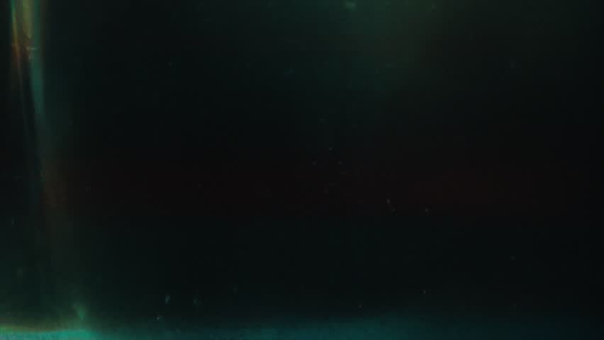 Cool-toned analog surface with teal and black gradient, subtle interference streaks, grainy retro flicker, lomo aesthetic with soft glowing light trails and minimal abstract details