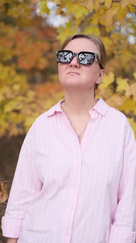 Stylish woman wearing sunglasses looking up at the sky