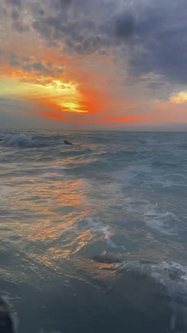 Powerful Ocean Waves at Sunset With Stormy Clouds
Vertical 4K footage of strong ocean waves hitting rocks during a dramatic sunset. Dark clouds, glowing orange horizon, and dynamic water motion create an intense natural scene. Ideal for cinematic backgrounds, emotional visuals, and social media content.