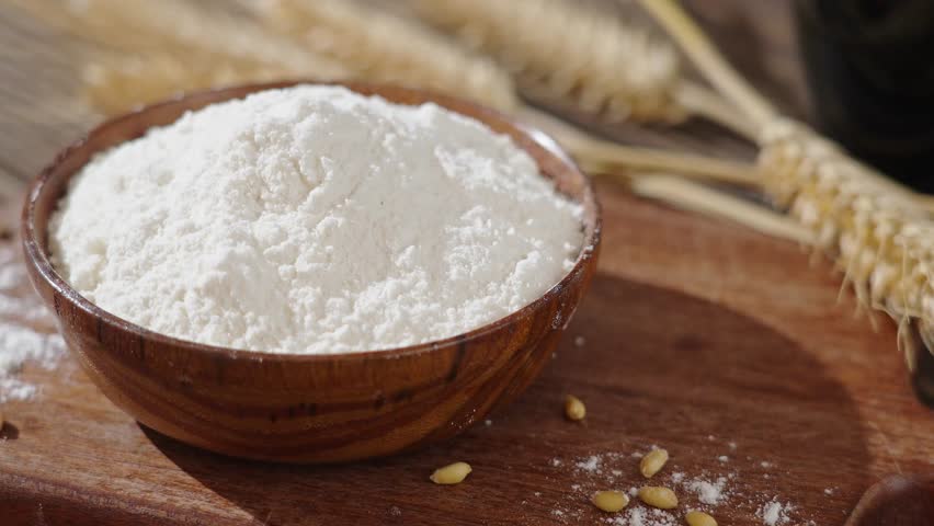 wheat flour and wheat ears on wooden table	