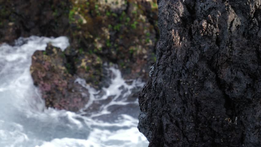 Close-up of rocks on the coast as the sea crashes against them