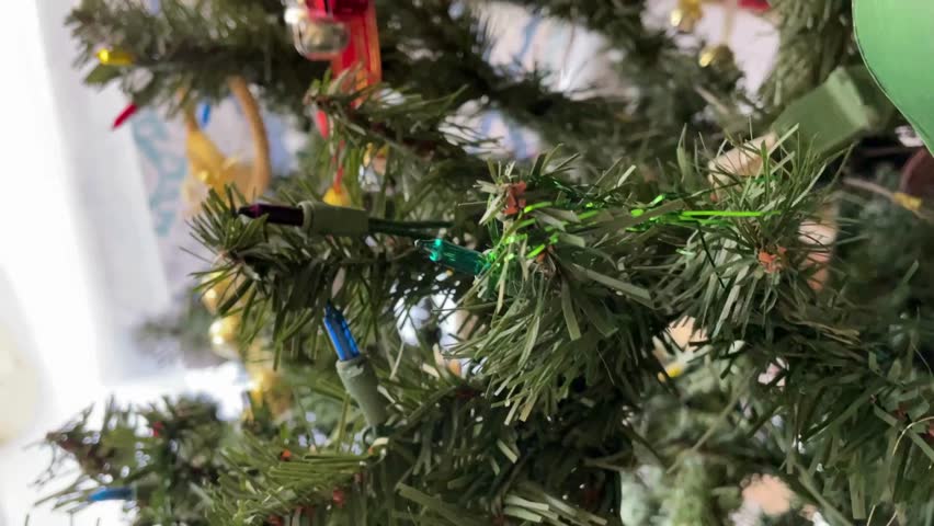 hanging Christmas tree decoration with decorations hanging and lights sparkling  