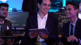 Professional business team discussing strategy in high-tech office. Diverse group of analysts using digital tablets to monitor global market data and software code on screens at night. - Powered by Shutterstock - Get 15% off with code: PIKWIZARD15