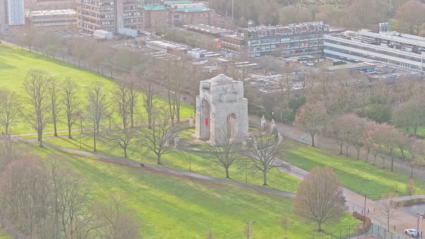 Arch of Remembrance First World War memorial in Victoria Park, Leicester, Leicestershire, England, showing the Lutyens stone arch with University of Leicester science and engineering buildings
