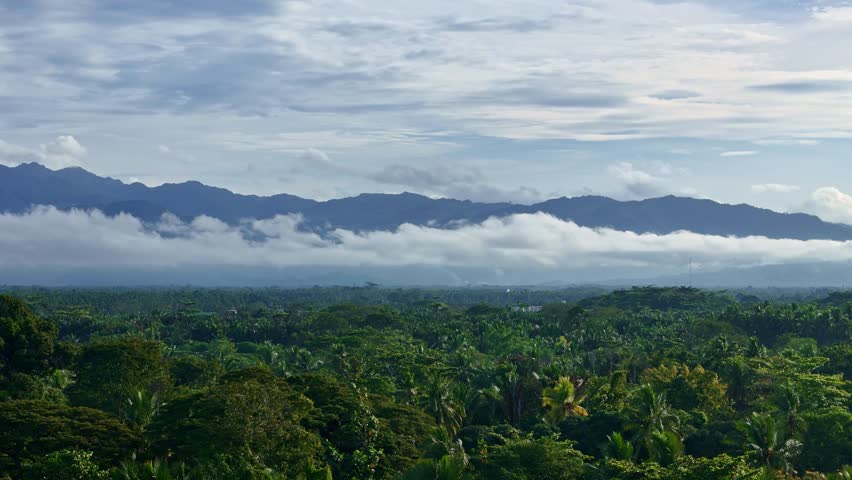 Cloud covered mountains near Butuan City, Philippines. Elevated view highlights natural terrain, drifting clouds, and a calm landscape suitable for nature and environment themes.