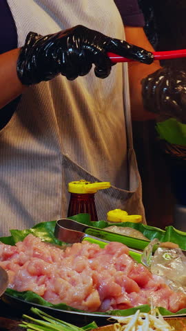 Vertical video. Cook Stir Frying Pad Thai in Flaming Wok at Thai Street Market in Low Angle Slow Motion View with Bright Fire Burst.