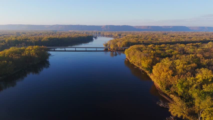 Calm waters and forested wetlands glimmer under soft morning light.