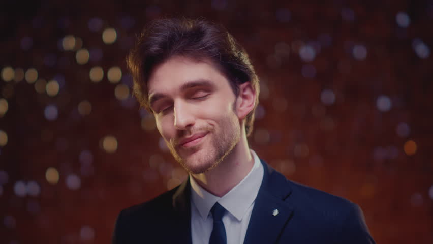 Portrait: handsome young man in a business suit. Male is an IT manager, lottery or casino winner, or showman. Face of leader guy is groom or guest at wedding. CEO businessman of a successful startup