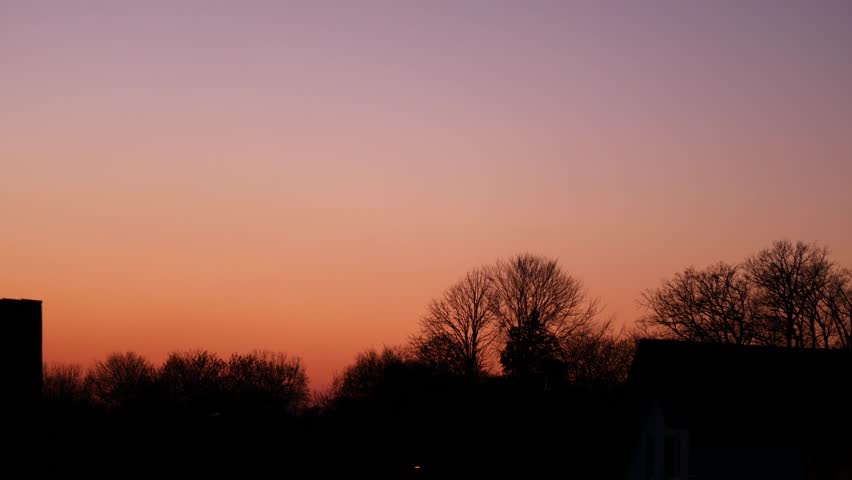 red orange sunset with outlines of trees