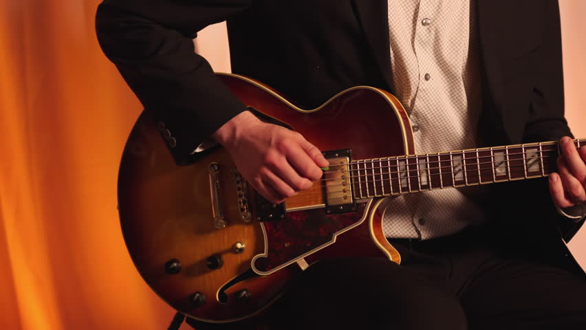 Male Band Member Playing An Electric Guitar On Stage. Close-up Shot