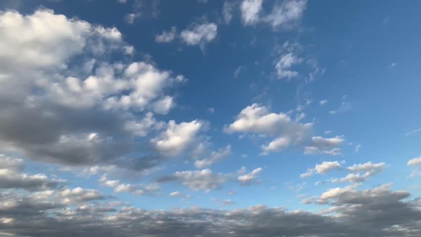 Sunset sky footage featuring clouds illuminated by late-day sunlight as they travel slowly across the frame during dusk and twilight. The scene shows a calm evening atmosphere with a soft, even spread of light and gentle color shift, making it easy to integrate into many real projects without distracting from a message. Use this clip as a sky background for broadcast graphics, weather segments, forecast visuals, documentary cutaways, and news-style transitions where a natural sky plate is needed. The continuous cloud motion supports time passage, pacing, and scene changes, and it works well behind titles, lower thirds, and introductory text because the frame provides usable negative space. Editors can also use it for presentation headers, website hero sections, channel bumpers, openers, and simple overlays that need an authentic outdoor context. The sunset palette suggests evening, closure, reflection, and a winding-down moment, which fits lifestyle storytelling, travel edits, and calm narration. Suitable for projects that require a neutral nature background, consistent lighting, and a steady sky surface with visible cloud layers and atmospheric depth, while keeping the focus on typography, voiceover, or foreground elements.