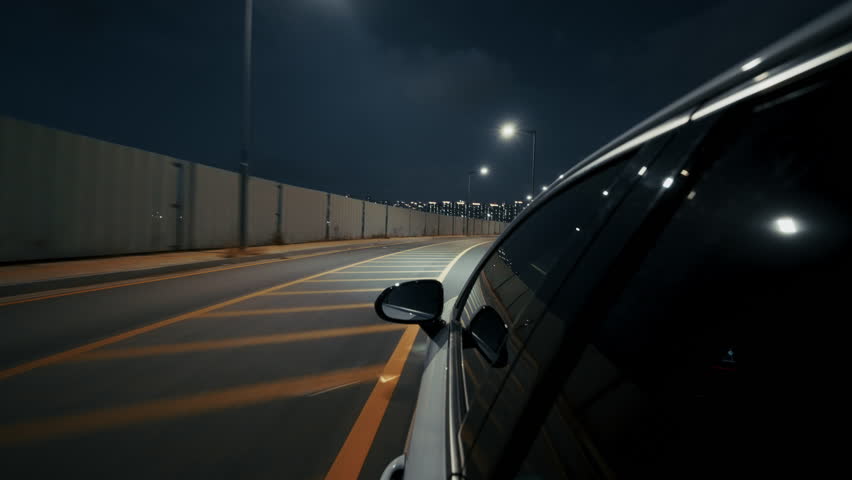 Cinematic night drive past Incheon skyline with modern skyscrapers and flowing city traffic