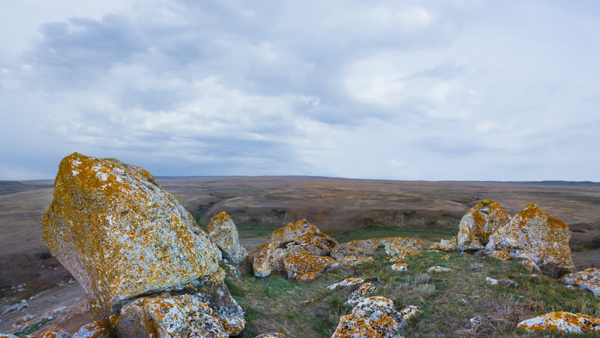 hill with stones among green prairie time lapse scene