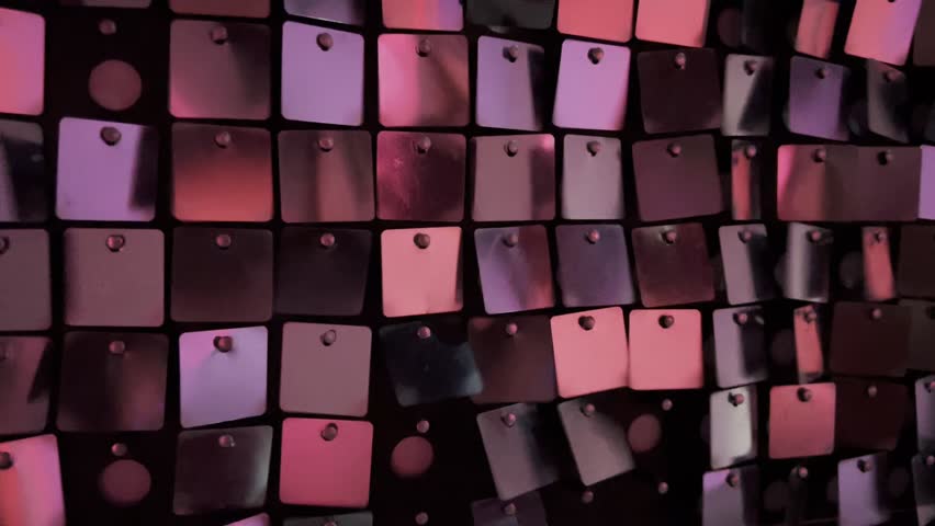 new years year celebration shimmering background featuring decorative wall covered in hundreds of small shiny square sequins pink purple red metallic tiles reflect light creating festive glam atmosphere textured surface shows regular grid arrangement of reflective plastic spangles modern interior design element event decoration backdrop nightlife party aesthetic luxury sparkling detail close up view fashion industry materials glitz glamour celebration mood disco style ornamentation shimmering effect
