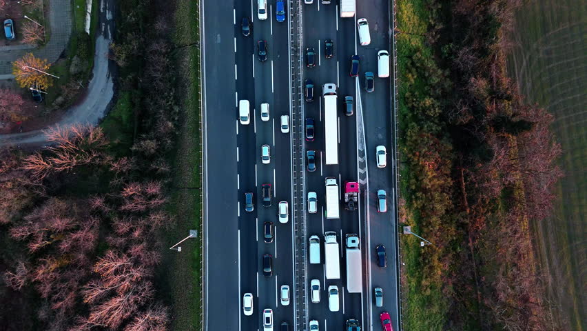 Aerial view of busy highway in autumn with vehicles and colorful trees