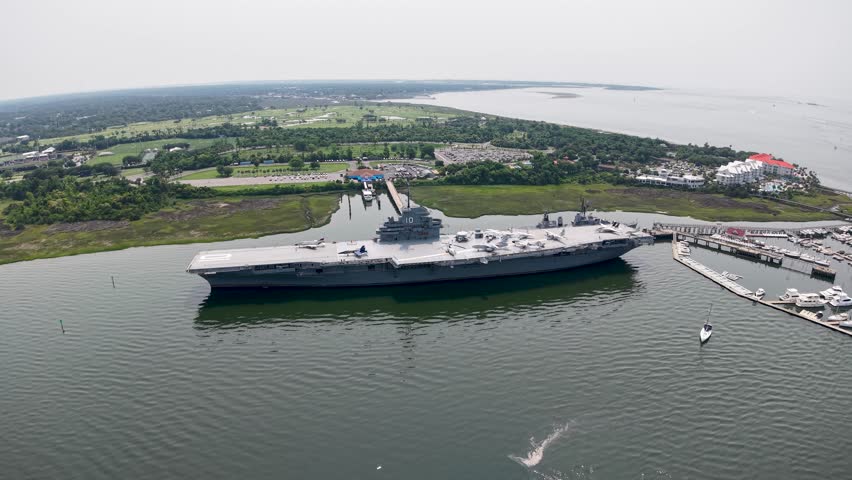 Drone footage showcases the historic USS Yorktown aircraft carrier docked at Patriots Point in Charleston, South Carolina, with surrounding harbor views and scenic coastal landscape.