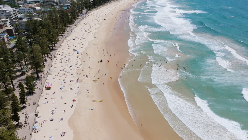 Aerial tilt shot overlooking people at the Manly Beach, in sunny Sydney, Australia