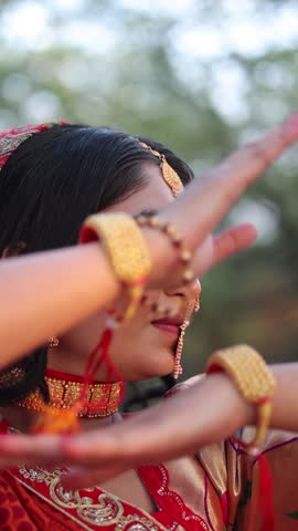 Beautiful Indian woman wearing an orange traditional lehenga choli and ethnic jewelry, posing and walking gracefully in a natural forest environment. Cultural Indian fashion video showcasing heritage attire, festive bridal style, and outdoor lifestyle concept