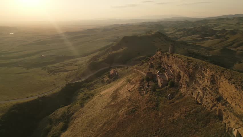 Aerial view Natlismtsemeli Monastery complex carved into cliffs, medieval Georgian Orthodox architecture in remote Kakheti hills. Part of David Gareja monastic complex. Azerbaijan Georgia border zone