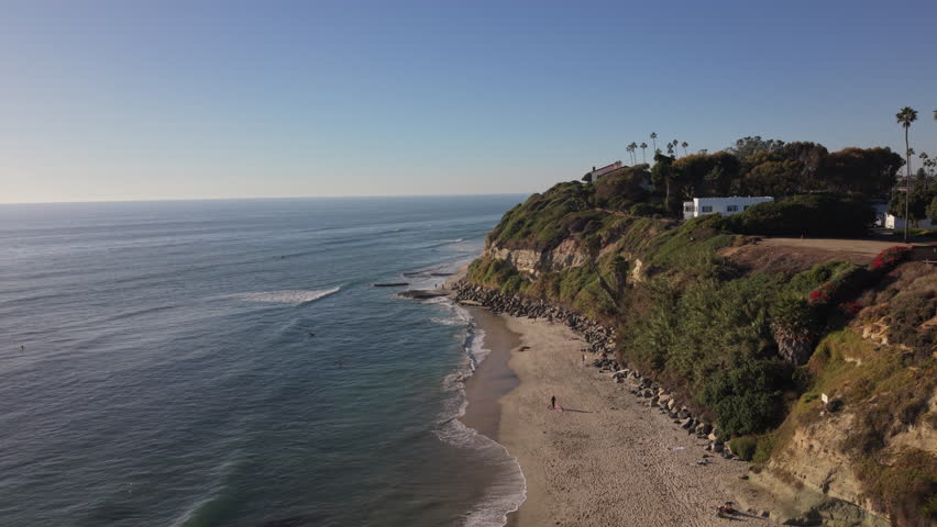 Swamis Beach in Encinitas, California. Surfers on the beach and in the water. Drone flyover.