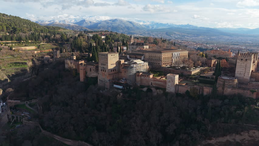 Panoramic aerial view of the Alhambra palace complex with the snowy Sierra Nevada mountains behind