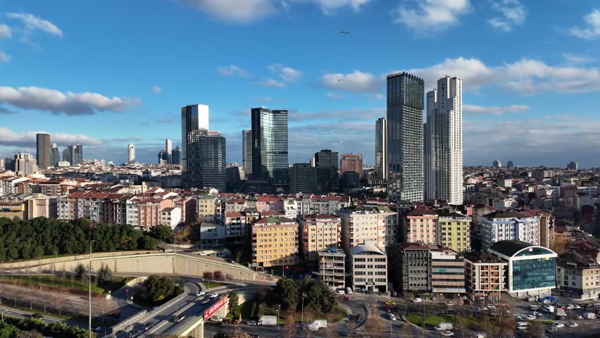 Aerial view of Istanbul city skyline with modern skyscrapers and dense residential buildings under blue sky with fluffy clouds, urban traffic and cityscape of Turkey