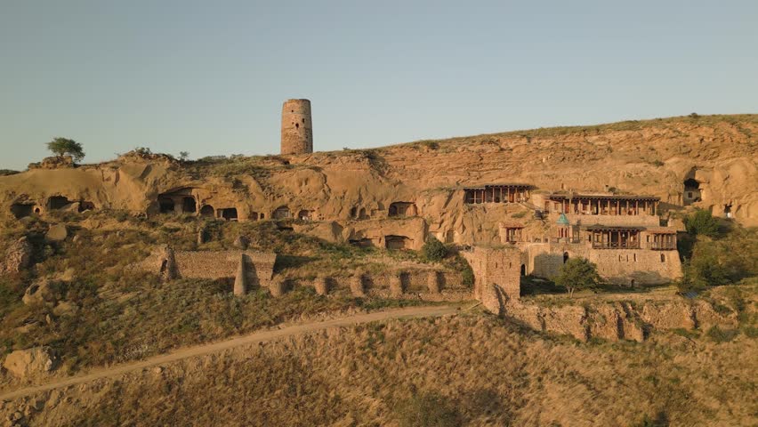 Aerial view Natlismtsemeli Monastery complex carved into cliffs, medieval Georgian Orthodox architecture in remote Kakheti hills. Part of David Gareja monastic complex. Azerbaijan Georgia border zone
