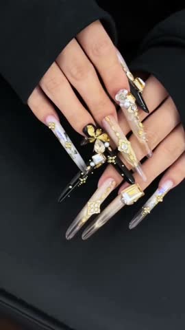 Close-up angled view of long oval golden glitter nails on a model’s hand