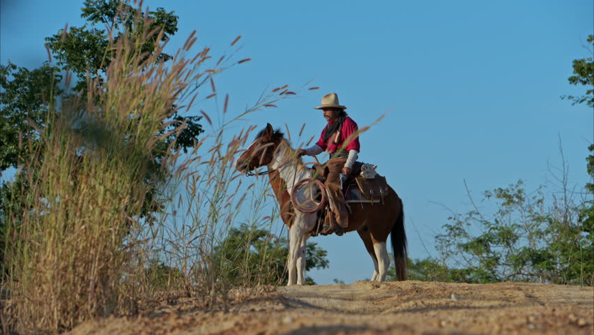 A cowboy on a rearing horse holding a revolver, capturing a classic and dramatic Wild West moment
