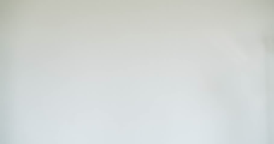 A man in a black t-shirt and an LED purge mask rips up a piece of paper. Themes of mystery, Halloween, and horror. White studio backdrop.