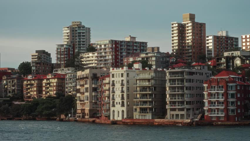 Urban Coastal Sunset, Serene Cityscape Featuring Coastal Apartments And Reflective Waters At Dusk