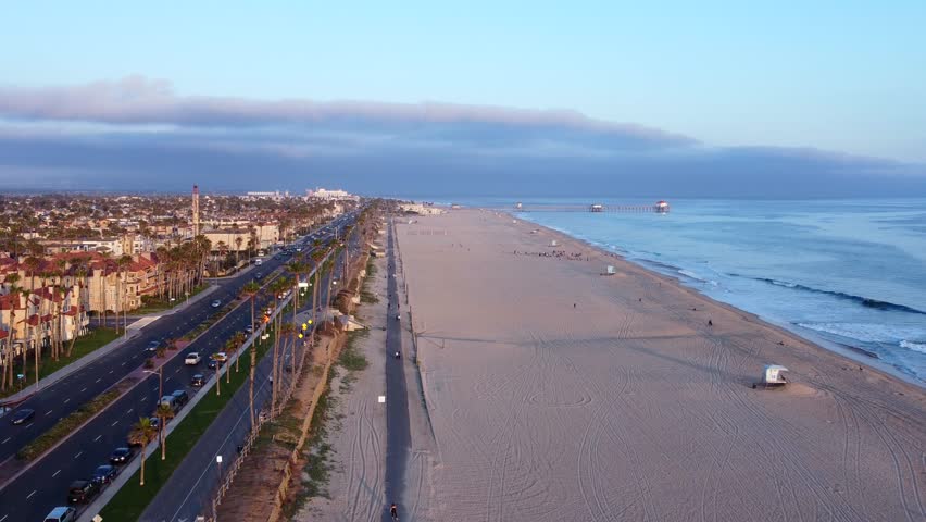 Coastal sunset view of Huntington Beach, Orange County, California - Pacific West Coast. Aerial Landscape looking toward HB Pier and residential ocean front neighbourhoods along PCH Highway.