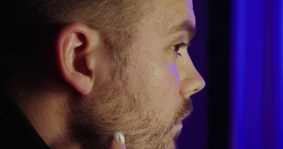 Close-up shot of a man putting wireless earbuds into his ears, highlighting modern audio technology and everyday lifestyle.
